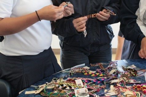 Students look through the hundreds of pulseras for sale for $5 this week in the high school dining hall. The fundraiser is junior Carolynn Krueger's senior product.